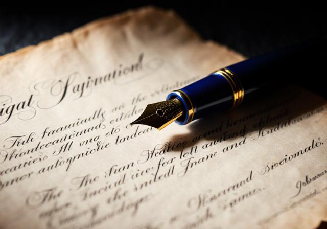 Close up of a fountain pen signing a heavy vellum contract document